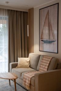 a living room with a couch and a sailboat on the wall at Marina Piaski Apartamenty in Piaski