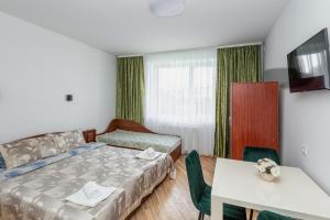 a bedroom with a bed and a table and a table and chairs at Vila Uosis in Palanga