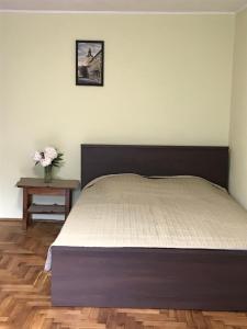 a bedroom with a bed and a table with a vase of flowers at Сколе Серце Карпат in Skole