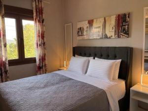 a bedroom with a bed with white pillows and a window at SpitiAyia in Ayiá