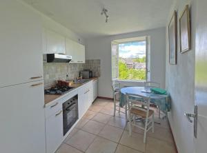 a kitchen with a table and a small kitchen with a window at Vue sur la Vezere in Treignac