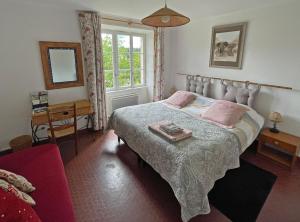 a bedroom with a bed and a table and a window at Vue sur la Vezere in Treignac