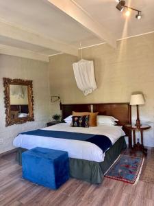 a bedroom with a large bed with a blue stool at Chocolate Orchid in White River