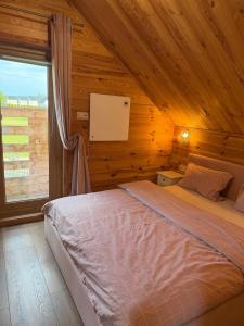 a bedroom with a bed in a wooden cabin at Luna House in Łoje