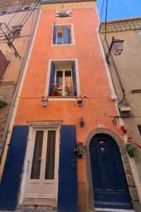 a building with a blue door and two windows at Grande chambre in Agde