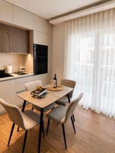 a dining room with a table and chairs and a kitchen at Sea & Sun Luxury Apartment in Alexandroupoli