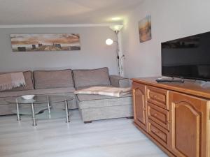 a living room with a couch and a flat screen tv at Ferienhaus Figelski in Sassnitz
