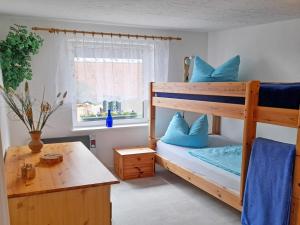 a bedroom with a bunk bed with blue pillows at Ferienhaus Figelski in Sassnitz +4 photos