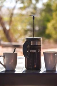 a coffee maker and two cups on a table at Kwelanga River Lodge in Vioolsdrif