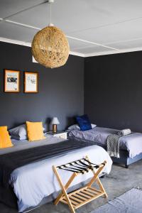 a bedroom with two beds and a chandelier at Kwelanga River Lodge in Vioolsdrif +84 photos