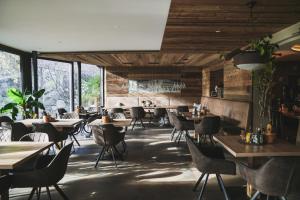 a restaurant with wooden walls and tables and chairs at Hotel Harpf in Bressanone