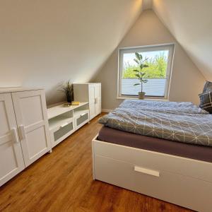 a bedroom with a bed and a window at Käpitänshaus zum Plümper in Ahrenshoop