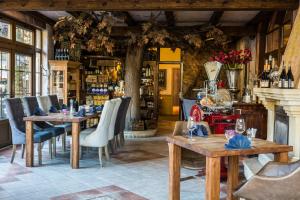 a restaurant with wooden tables and chairs and a fireplace at Bonato Hotel in Náchod