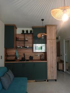 a kitchen with green cabinets and a microwave at Studio ONE in Kiten