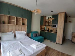a bedroom with a large bed and a kitchen at Studio ONE in Kiten