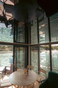 a table and chairs in a room with windows at Solina Houseboat Polańczyk in Polańczyk
