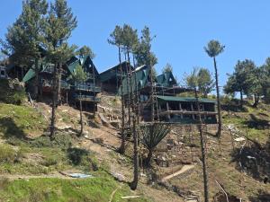a resort on the side of a hill with trees at Dar Al Masyaf in Sharan