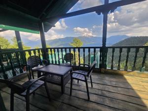 a table and chairs on a porch with a view of mountains at Dar Al Masyaf in Sharan