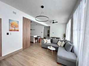 a living room with a gray couch and a table at Villa La Vida Dulce Private Pool Near Playa Dorada in Puerto Plata