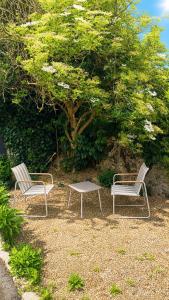 two chairs and a table in front of a tree at Montoir-de-Bretagne in Montoir-de-Bretagne