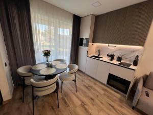 a kitchen and a table and chairs in a room at Cozy Home Oasis in Palanga