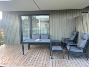 a patio with a table and chairs on a deck at Cozy Home Oasis in Palanga
