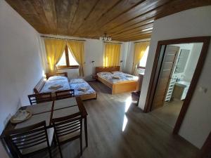 a room with two beds and a table and chairs at U Belianky in Terchová