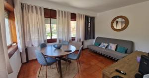 a living room with a table and chairs and a couch at Varinos House Praia in Alvor