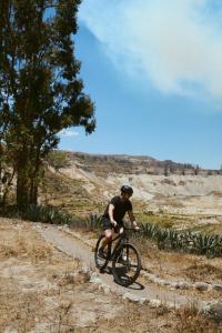 a man riding a bike down a dirt road at Las Casitas, A Belmond Hotel, Colca Canyon in Yanque