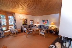 a living room with a couch and a table and chairs at Schweizerhof Drescher 612 in Lenzerheide +11 photos