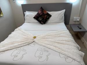 a bed with a white comforter with a bow on it at JH Guest house in Durban +24 photos
