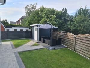 a garden with an umbrella and a fence at Haus Strandoase Nr 4 in Oldenburg in Holstein