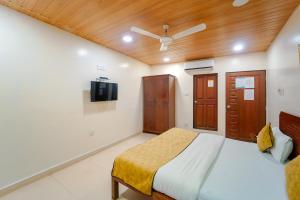 a bedroom with a bed and a tv on the wall at The New Hill Retreat in Mahabaleshwar