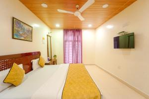 a bedroom with a bed with a ceiling fan and a tv at The New Hill Retreat in Mahabaleshwar