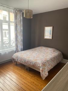 a bed sitting in a bedroom with a window at Logement Océan in Boulogne-sur-Mer
