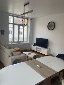a living room with a couch and a tv at Logement Océan in Boulogne-sur-Mer