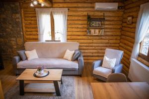 a living room with a couch and a chair and a table at Brvnara Vasić - Stara planina in Pirot