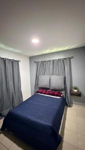a bedroom with a bed with a blue comforter at Departamento scorpio in Tuxtla Gutiérrez