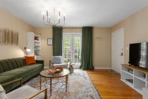 a living room with a green couch and a tv at Plaza Condo With Queen Bed 3 in Kansas City