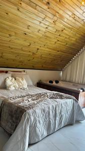 a bedroom with a bed with a wooden ceiling at Sombra do baú - Aurora in Timbe do Sul
