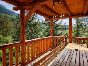 a wooden porch with a wooden bench on the deck at Brvnara Vasić - Stara planina in Pirot