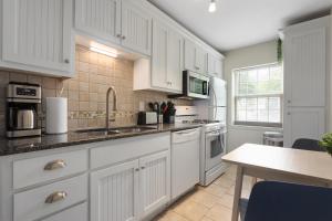 a kitchen with white cabinets and a counter top at Plaza Condo With Queen Bed 3 in Kansas City