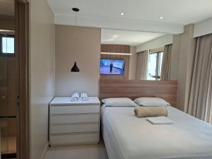 a bedroom with two beds and a tv on the wall at Brisa Calma Premium Flat - PontaNegra in Natal +18 photos
