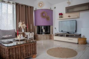 a living room with a tv and a table at Christina's Home in Skiathos +41 photos