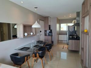 a kitchen with a table and chairs in a room at Brisa Calma Premium Flat - PontaNegra in Natal