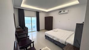 a bedroom with a bed and a view of the ocean at Family Beach Villas in Salalah