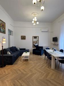a living room with a blue couch and a table at Katerina Apartman in Gyula