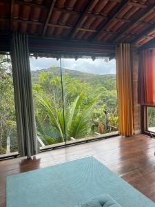 a room with a large window with a blue rug at Golden refuge in Vale do Capão in Passagem