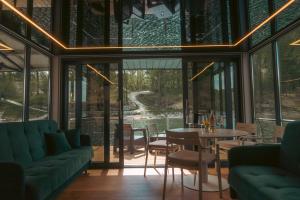 a glass house with a table and chairs at Solina Houseboat Polańczyk in Polańczyk