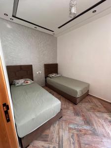 a small bedroom with two beds and a ceiling at Jaouhar immo in Martil